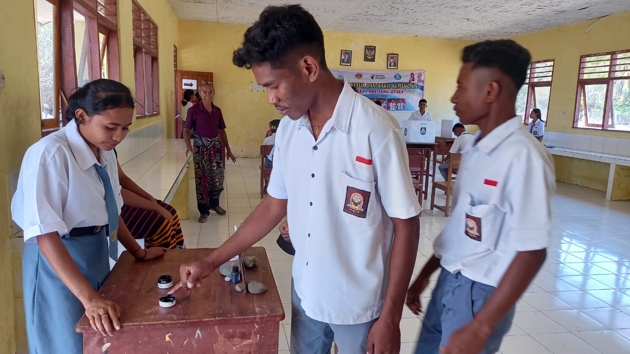 Salah seorang siswa mencelupkan jarinya sebagai bukti bahwa telah melakukan Pemilihan